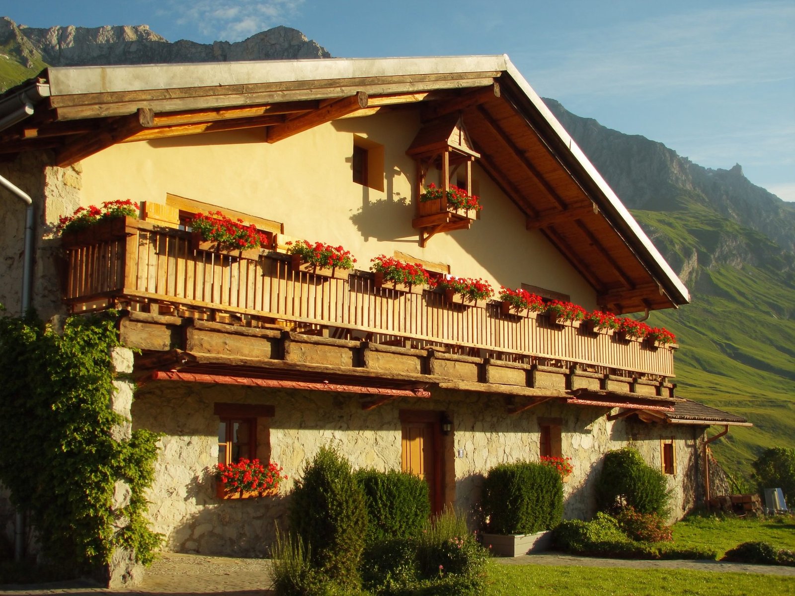 Balcon fleuri d'une maison savoyarde face à la vallée